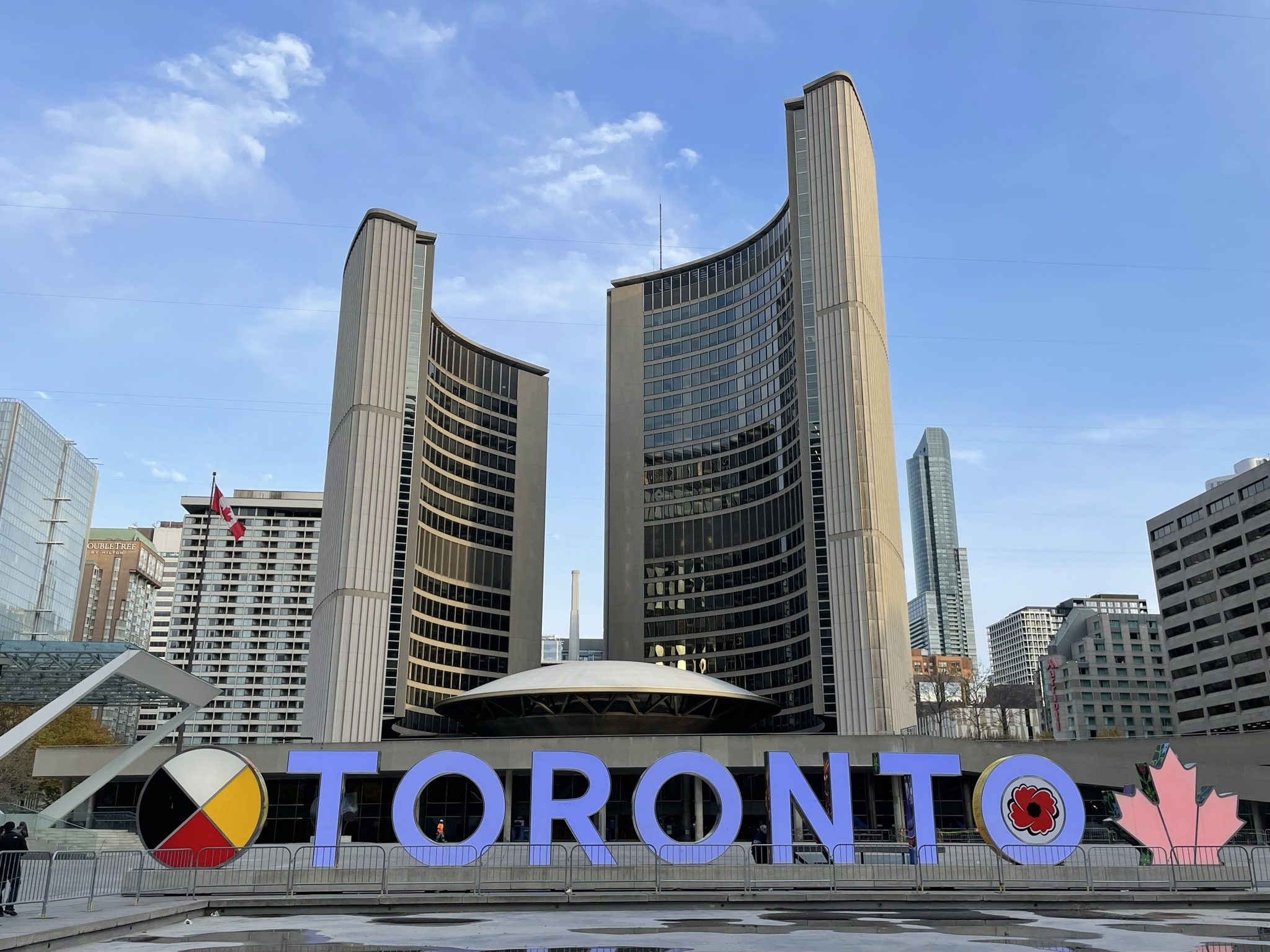 The colourful Toronto sign in Nathan Phillips Square, with Toronto City Hall behind it.